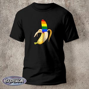 Könnte beinhalten: Schwarzes T-Shirt mit einer Grafik einer Banane mit Regenbogen-Schale. Die Banane ist geschält und gibt die Regenbogenfarben frei. Das T-Shirt hat einen Rundhalsausschnitt und kurze Ärmel. Das Design ist mittig auf der Vorderseite des Shirts.