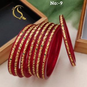 May include: Set of red glass bangles with gold and green accents. The bangles are stacked and arranged in a circle. The text on the image reads "Size:-2.2/2.4/2.6/2.8/2.10 1475:-R No:-9"