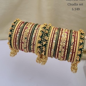 May include: A set of green, red and gold bangles with intricate designs and dangling charms. Rajwadi Met Chudla set S.149.
