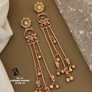 May include: Gold-toned Kashmiri earrings with floral and dangling elements. The earrings feature red and green accents, small clear stones, and a delicate chain design. The earrings have a drop length of approximately 5 inches.