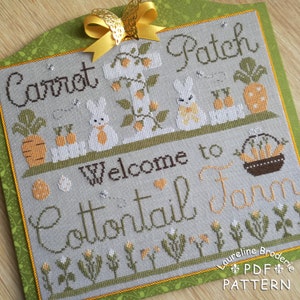 May include: Cross stitch pattern for a bunny rabbit themed design. The pattern features a white bunny rabbit, carrots, and the text "Carrot Patch Welcome to Cottontail Farm".