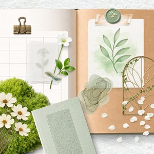 May include: An open journal with a light green cover and floral embossed design, featuring decorative elements. Includes a brass clip, a watercolor leaf painting, and a gold metal arch with vines. White flower petals and a mossy green base add to the aesthetic.