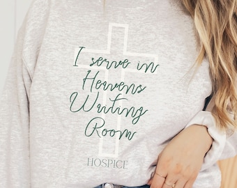 May include: A gray sweatshirt with a white cross and the text "I serve in Heaven's Writing Room HOSPICE" printed on the front.