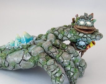 Figuurtje van een babygolem die zich vastklampt aan de hand van zijn moeder.