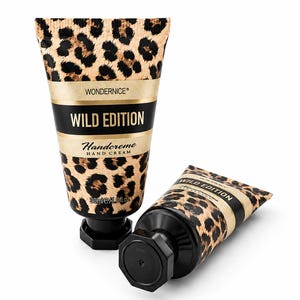 Könnte beinhalten: Zwei Tuben WONDERNICE Wild Edition Handcreme mit Leopardenmuster. Jede Tube hat einen schwarzen achteckigen Verschluss, ein schwarzes Querband mit dem goldenen Schriftzug WILD EDITION und ein Fassungsvermögen von 30 ml.