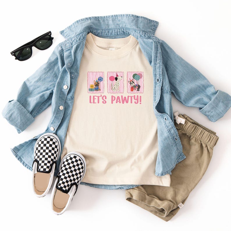 May include: A cream-colored t-shirt with the text "LET'S PAWTY!" and three dog illustrations. The shirt is paired with a light blue denim shirt, khaki shorts, black and white checkered slip-on shoes, and black sunglasses.
