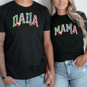 May include: A couple wearing matching black t-shirts with a fishing-themed design. The man's shirt says "DADA" and the woman's shirt says "MAMA".