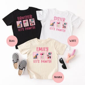May include: Three short-sleeved t-shirts in black, white, and natural colors. Each shirt has a pink graphic with the text "BROTHER", "SISTER", or "EMILY" above the phrase "LET'S PAWTY!" and dog illustrations.