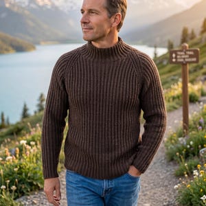 Peut inclure: Un pull en tricot côtelé marron foncé à manches longues, doté d'un col montant et de manches raglan, associé à un jean bleu classique. Le pull présente une texture verticale épaisse sur tout le corps et les manches avec un ourlet ajusté.