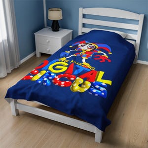 May include: A blue twin-sized bedspread with a cartoon jester and the text "The Amazing Digital Circus".