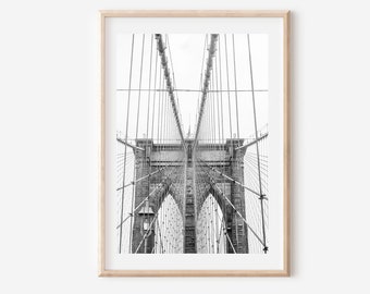Puede incluir: Fotografía en blanco y negro del puente de Brooklyn en la ciudad de Nueva York. La imagen se toma desde abajo del puente, mirando hacia arriba los cables de suspensión y las torres.