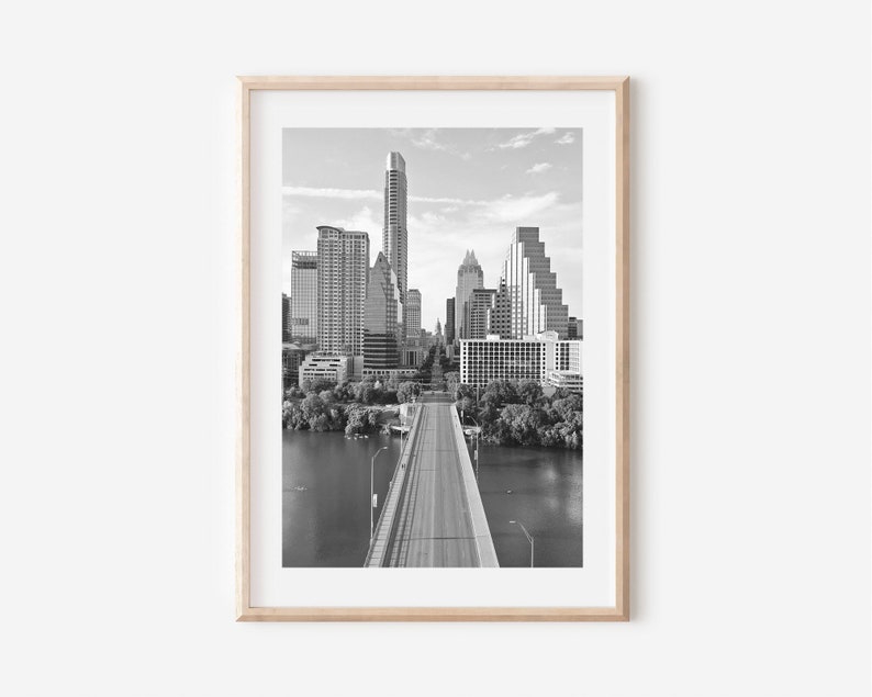 K&ouml;nnte beinhalten: Ein Schwarzwei&szlig;foto der Skyline von Austin, Texas, mit einer Br&uuml;cke, die zur Stadt f&uuml;hrt. Das Foto ist von oben aufgenommen und zeigt die Br&uuml;cke und die Stadt.