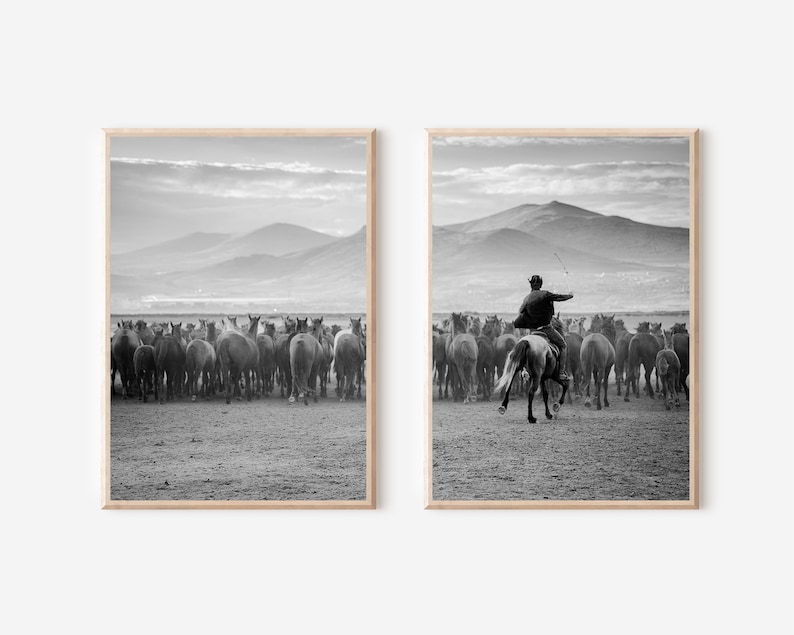 May include: A pair of framed black and white prints. One shows a herd of horses from behind, the other a cowboy on horseback herding the horses. Mountains are in the background.