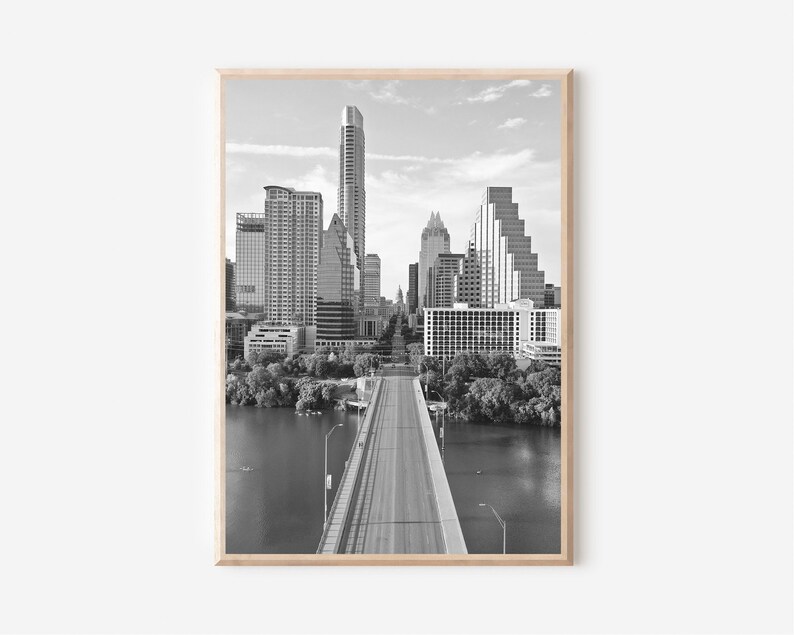 K&ouml;nnte beinhalten: Ein Schwarzwei&szlig;foto einer Skyline mit einer Br&uuml;cke, die zur Stadt f&uuml;hrt. Die Br&uuml;cke ist leer und die Stadt befindet sich im Hintergrund.