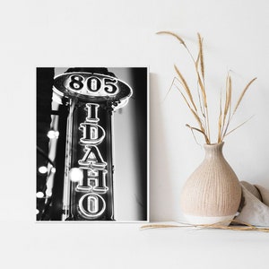May include: Black and white photograph of a neon sign that reads "805 IDAHO" in a vintage style.