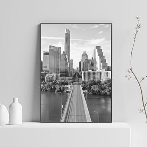 K&ouml;nnte beinhalten: Schwarzwei&szlig;foto der Skyline von Austin, Texas, mit einer Br&uuml;cke, die in die Stadt f&uuml;hrt.