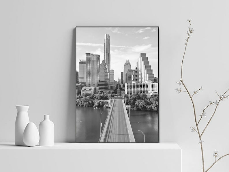K&ouml;nnte beinhalten: Schwarzwei&szlig;foto der Skyline von Austin, Texas, mit einer Br&uuml;cke, die in die Stadt f&uuml;hrt.