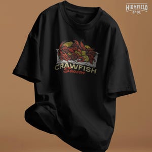 Cajun crawfish design PNG with rich red shell color, corn kernels, and lemon wedges arranged in a classic boil presentation. Suitable for summer party shirts and seafood lover gifts.