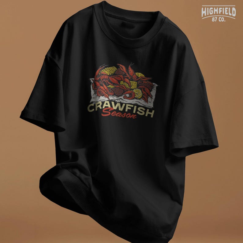 Cajun crawfish design PNG with rich red shell color, corn kernels, and lemon wedges arranged in a classic boil presentation. Suitable for summer party shirts and seafood lover gifts.