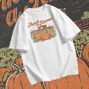 Fall farm PNG showing a pumpkin harvest scene with oversized pumpkins in the foreground and a combine harvester in the distance. Bold lettering reads “Thank a Farmer.”
