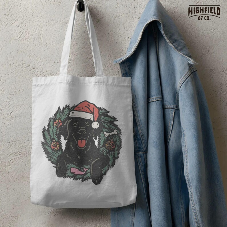 Pet Christmas design showing black Labrador retriever in pine wreath with red ornaments. Digital file for holiday sublimation.