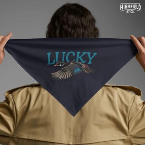 Duck lover gift PNG showing a colorful flying wood duck with expressive feathers and large Lucky lettering. This clean digital design works well for outdoor shirts, bird lover sweatshirts, waterfowl apparel, and nature themed creative projects.