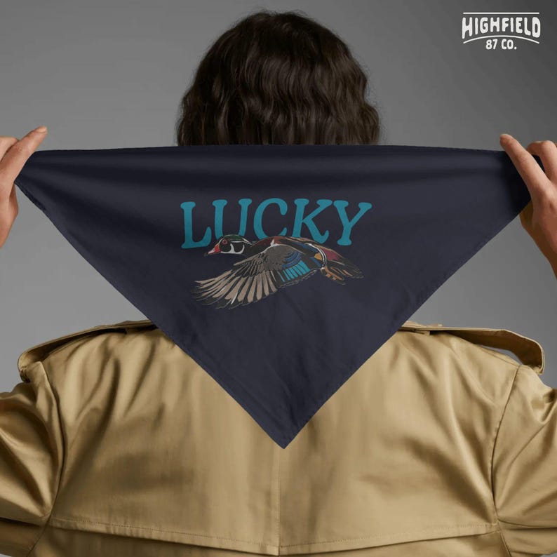 Duck lover gift PNG showing a colorful flying wood duck with expressive feathers and large Lucky lettering. This clean digital design works well for outdoor shirts, bird lover sweatshirts, waterfowl apparel, and nature themed creative projects.