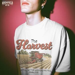 Farmer shirt PNG showing a combine in a corn field with The Harvest lettering for Christian agriculture apparel.