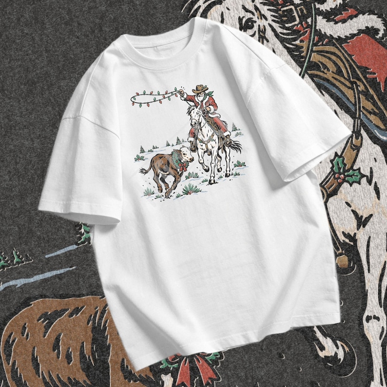 Cowboy Christmas design featuring Santa riding a white horse beside a festive calf with evergreen greenery, red berries, and holiday ribbon.