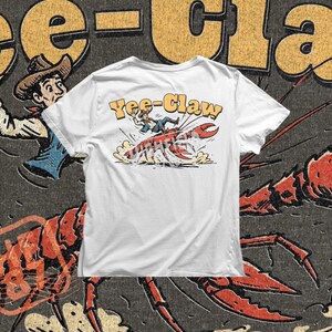 Yee Claw crawfish illustration showing a cowboy riding a giant crawdad in a humorous rodeo style scene. The crawfish runs across the ground while dust flies around the claws, creating a fun Cajun themed design inspired by Louisiana crawfish boil culture.