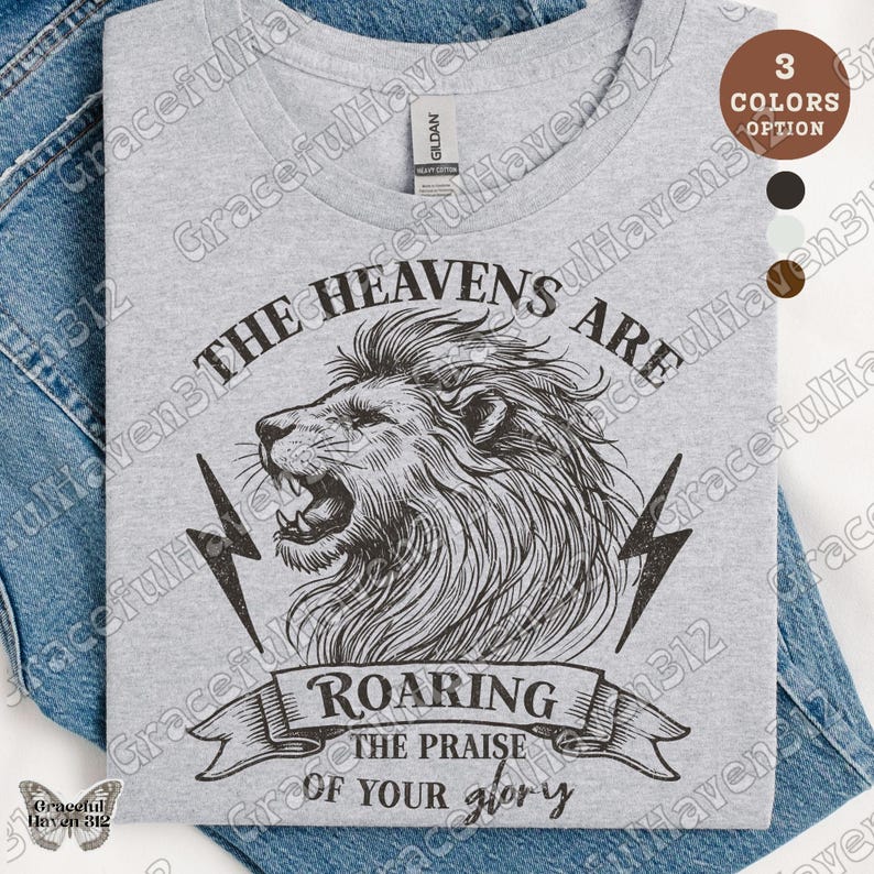 May include: A gray t-shirt with a lion graphic and the text "The Heavens Are Roaring The Praise Of Your Glory".