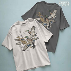 Duck hunting shirt PNG featuring a trio of flying mallards with open wings and natural wildlife colors.