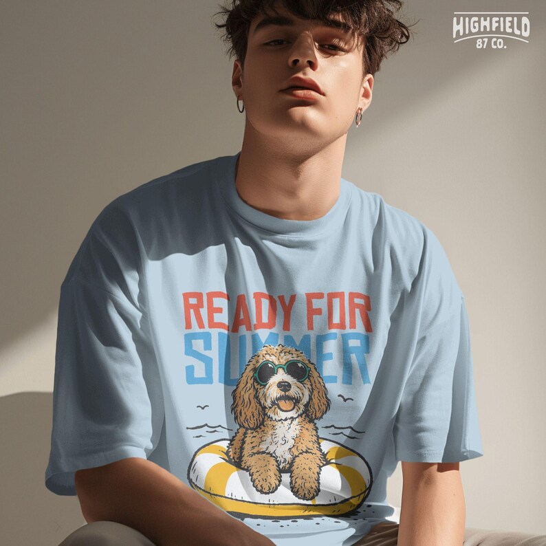 Summer shirt PNG with a cute fluffy dog wearing sunglasses, relaxing in a yellow float, and bold beach-inspired lettering for seasonal apparel designs.