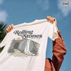 Rolling stone Jesus tomb PNG, cross silhouette sunrise PNG, Christian religious message PNG, Jesus resurrection digital art, biblical scene download PNG, Easter tomb illustration, church bulletin art PNG, cross and grave artwork, risen Christ t-shirt graphic, grace filled Easter art PNG, rolling stones since AD 33 design, Christian hope sunrise PNG, Easter printable card design, vintage ministry art, Christian apparel design PNG, gospel faith wall art PNG, He is risen poster PNG