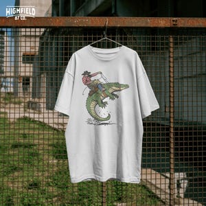 Western rodeo PNG featuring cowboy riding alligator with strong silhouette design