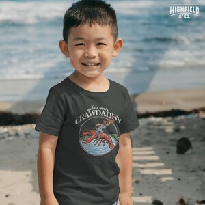 funny fishing crawdad graphic with cowboy rider for unique southern apparel designs