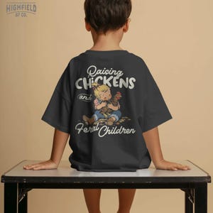 Homestead PNG showing a farm kid cuddling a hen with funny chicken family phrase for backyard chicken shirts.