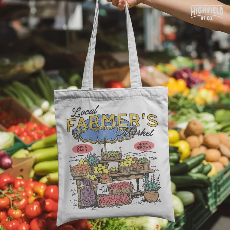Farmers market shirt PNG featuring a local produce booth with baskets, blue umbrella, and fresh fruit stand details for small business projects.