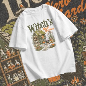 Witchy fall PNG showing Witchs Herb Garden text above a Halloween cottage with cauldron, pumpkins, plants, broom, and flowers.