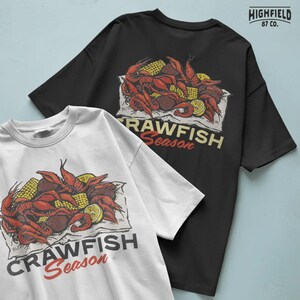 Crawfish Season artwork PNG capturing the vibrant red shells of crawfish paired with corn and lemon accents. Created for seafood boil shirts and summer outdoor festival apparel.