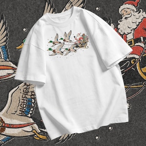 Mallard Christmas design showing Santa waving from a black sleigh while four ducks with green heads and brown chests fly in front wearing leather harnesses.