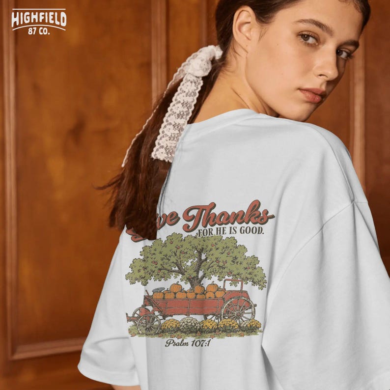 Faith shirt PNG showing a Thanksgiving harvest wagon, pumpkins, apple tree, and Psalm 107 1 scripture inspired message.