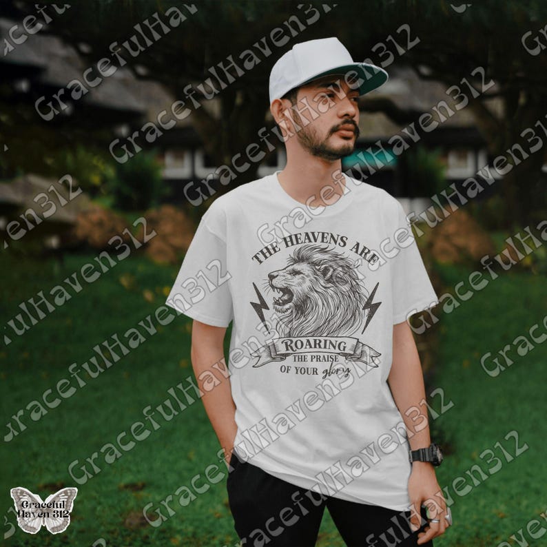 May include: White t-shirt with a black and white illustration of a lion with the text "The Heavens Are Roaring The Praise Of Your Glory".