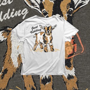 Just Kidding goat PNG featuring a sweet little goat with a playful expression and hand lettered phrase, perfect for funny goat shirts and farm themed apparel.