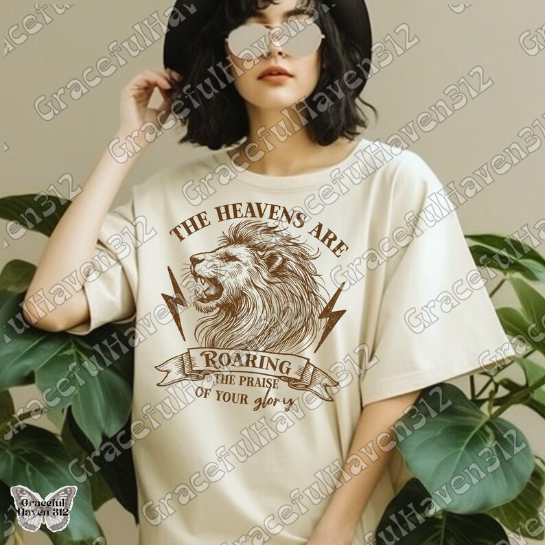 May include: A beige t-shirt with a graphic of a roaring lion and the text "The Heavens Are Roaring The Praise Of Your Glory".