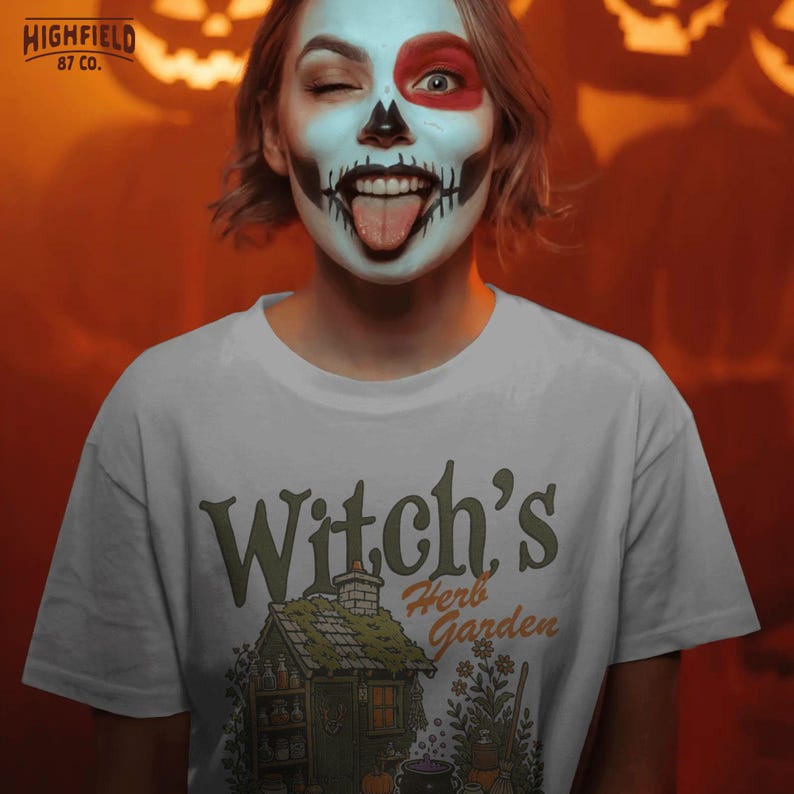 Halloween shirt PNG showing a witch herb garden scene with cottage, potion shelf, pumpkins, broom, flowers, and spooky garden artwork.