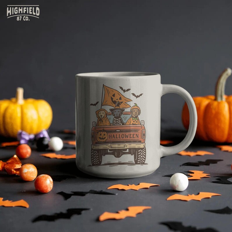 Dog costume PNG featuring a Halloween pickup truck, pumpkin tailgate art, flying bats, and three festive dogs in cute spooky outfits.