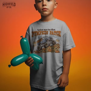 Boys fall PNG showing a monster truck in a pumpkin patch with orange pumpkins, fall field details, and playful autumn shirt style.