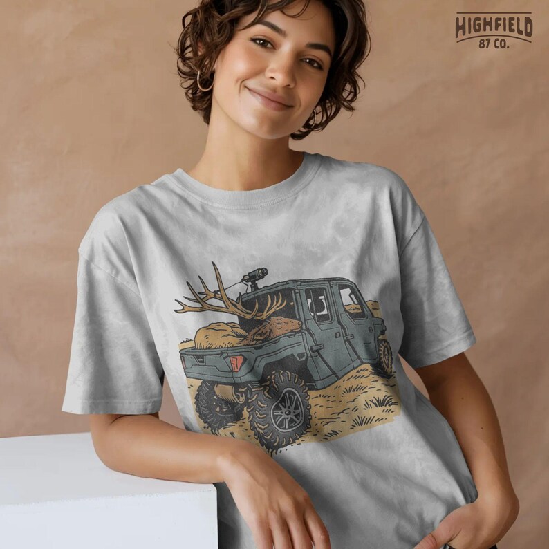 Hunting UTV with a full rack elk in the truck bed, set in an outdoor field. The antlers stretch above the tailgate. Use this antler hunt PNG for hunting gear artwork, printable designs, or shirt transfers.