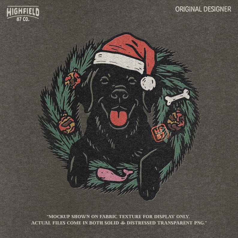 Festive black lab retriever sitting in green Christmas wreath with red baubles, dog bone, and holiday Santa hat. PNG clipart for Labrador Christmas designs.